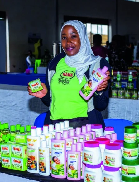 An exhibitor presents bottles and jars of personal-care products at her stand.