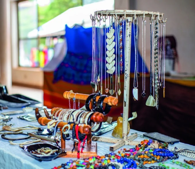 Necklaces, bracelets and handmade accessories displayed on an exhibition table.