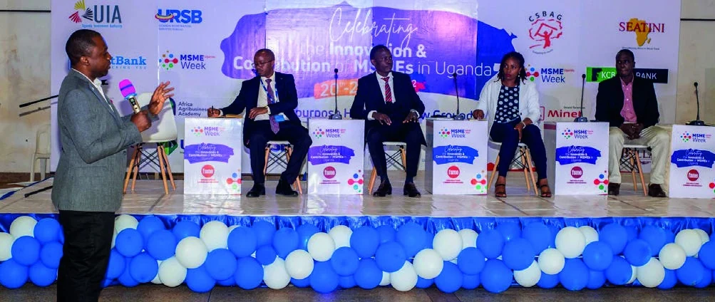 A moderator addresses four panelists on the MSME Week stage.
